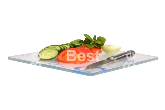 Cucumbers, onions, tomatoes on a glass cutting board