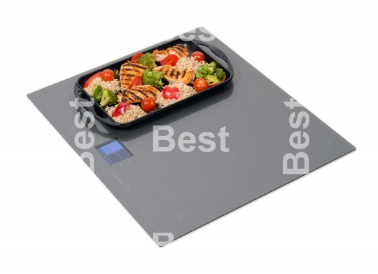Grey glass induction hob with roast chicken