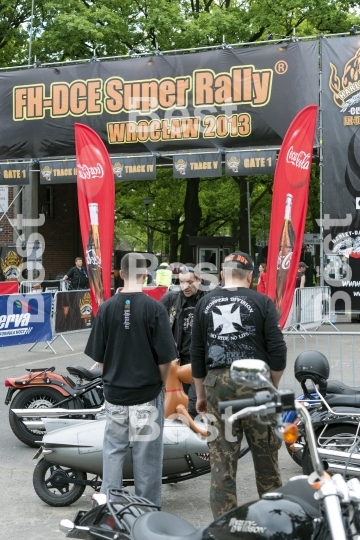 Harley Davidson motorcycle riders in front of the gate "Harley-Davidson Super Rally 2013"