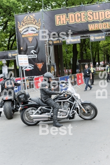 Harley Davidson motorcycle riders in front of the gate "Harley-Davidson Super Rally 2013"