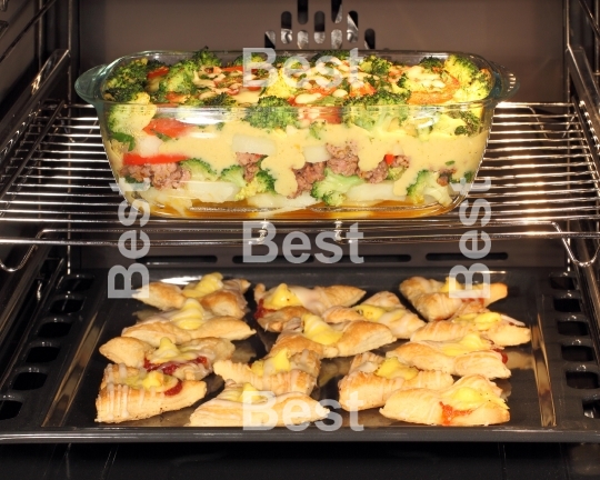 Homemade cookies and casserole dish in oven