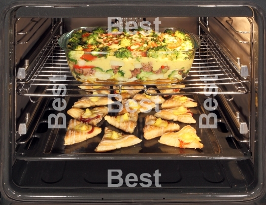 Homemade cookies and casserole dish in oven