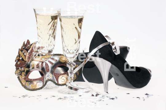 Masquerade mask, champagne and high heel shoes