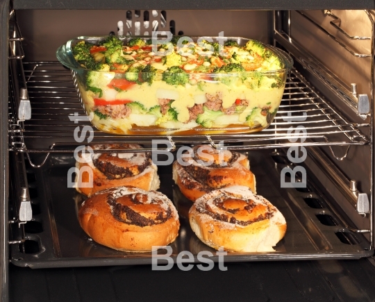 Poppy seed rolls and casserole dish in oven