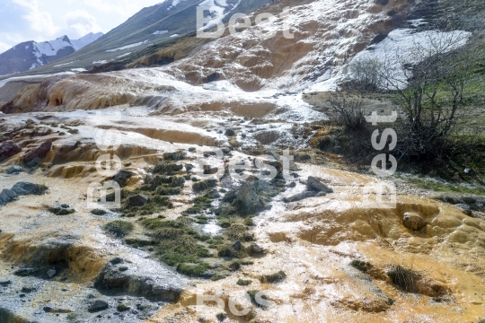 A living source of mineral water flowing to the surface causing calcium deposition (travertine)