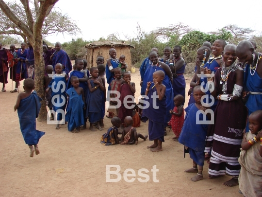 Masai performance in a traditional Masai village. Women with children singing and watching their men performance. 