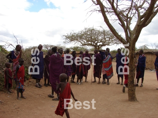 Masai performance in a traditional Masai village. Women with children singing and watching their men performance. 