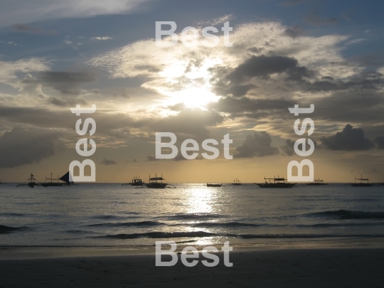 Sail boats on the ocean at sunset