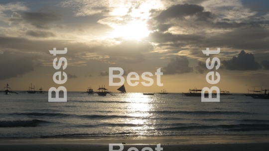 Sail boats on the ocean at sunset